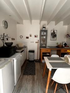 eine Küche mit einem Tisch und eine Küche mit einer Theke in der Unterkunft Duplex - T3 in Portet-sur-Garonne