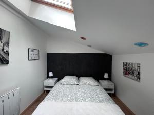 ein Schlafzimmer mit einem großen Bett und zwei Nachttischen in der Unterkunft Duplex - T3 in Portet-sur-Garonne