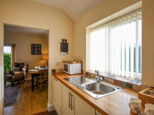 a kitchen with a sink and a microwave at The Old Milking Parlour in Melverley
