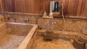 a bathroom with a tub and a sink and a mirror at Ryoso Kawaguchi in Miyajima +37 photos