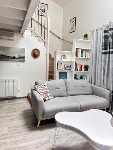 ein Wohnzimmer mit Sofa und Tisch in der Unterkunft Duplex - T3 in Portet-sur-Garonne