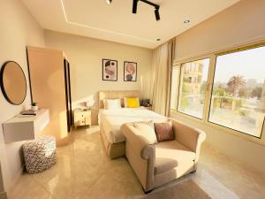 a bedroom with a bed and a couch and a chair at ROOMES NILE VIEW MANIEl in Cairo