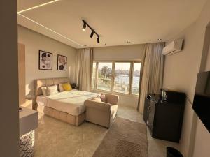 Un dormitorio con una cama y un sofá y una ventana. en ROOMES NILE VIEW MANIEl, en El Cairo