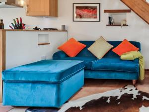 un sofá azul con almohadas coloridas en la sala de estar. en Katy, en Meare
