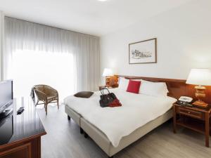 a hotel room with a bed with a bag on it at Aparthotel Adagio Rome Vatican in Rome