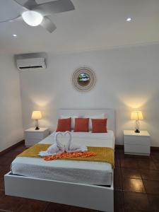 a bedroom with a bed with two night stands and two lamps at Lagoa Fabulous House in Lagoa +10 photos