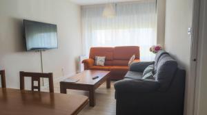 a living room with a couch and a table at AMPLIO APARTAMENTO EN BURELA in Burela de Cabo