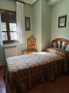 une chambre avec un lit, une chaise et une fenêtre dans l'établissement Casa Angel, à Santa Cilia de Jaca