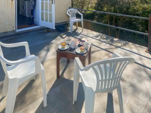 zwei Stühle und ein Tisch mit einem Teller mit Essen darauf in der Unterkunft Elsewhere in Penzance