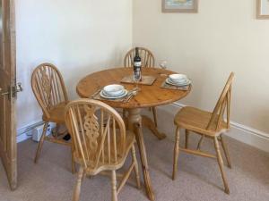 einen Holztisch mit Stühlen und eine Flasche Wein in der Unterkunft Elsewhere in Penzance