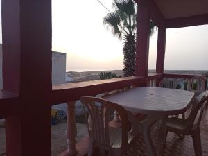 Una mesa y sillas en el balcón de una casa. en tasurft house imsoune, en Imsouane