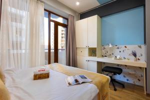 a bedroom with a bed and a desk and a window at Apartment KeyGo #0067 near Yerevan Fortress in Yerevan