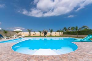 a large swimming pool with a water slide at Jungle Holiday Villa in Marina dʼAvola