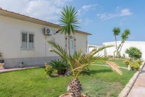 a pineapple in a yard in front of a house at Jungle Holiday Villa in Marina dʼAvola