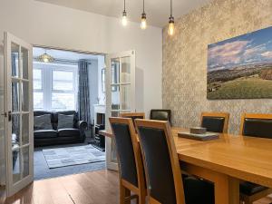 a dining room with a wooden table and chairs at Hollybush Cottage in Buxton