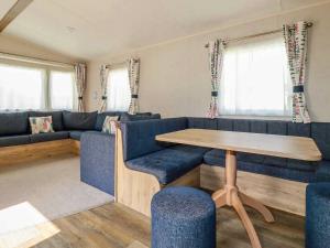 a living room with a blue couch and a wooden table at 82 Hillside in Newquay