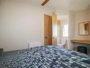 a bedroom with a bed and a bathroom with a toilet at 82 Hillside in Newquay