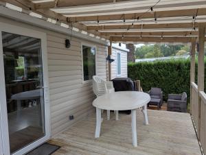 a patio with a table and chairs on a deck at Camping les charmettes in Les Mathes