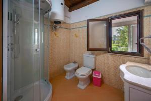 a bathroom with a toilet and a sink and a shower at Jungle Holiday Apartment in Marina dʼAvola +20 photos