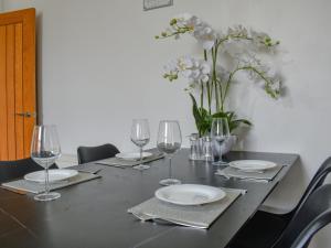 una mesa con vasos y platos y un jarrón de flores en Southgate House - Uk48863, en Elland