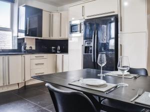cocina con mesa y 2 copas de vino en Southgate House - Uk48863, en Elland