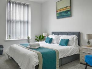 Un dormitorio con una cama grande con almohadas azules. en Southgate House - Uk48863, en Elland