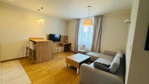 a living room with a couch and a table at Apartamenty Bistro12 in Sokoły