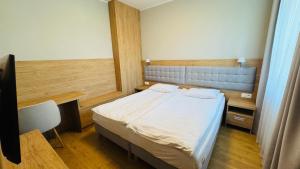 a bedroom with a bed and a desk and a chair at Apartamenty Bistro12 in Sokoły