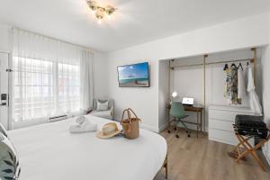 Un dormitorio blanco con una cama y un escritorio. en Bianco Hotel, en Miami