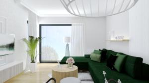 ein Wohnzimmer mit einer grünen Couch und einem Tisch in der Unterkunft Apartament Margaret in Oppeln