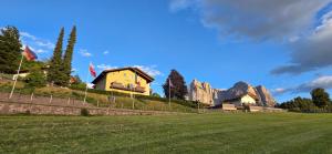 a house on a hill with mountains in the background at Solaia Hotel & Guesthouse in Castelrotto
