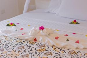 Una bata blanca sobre una cama en Leopard House, en Watamu