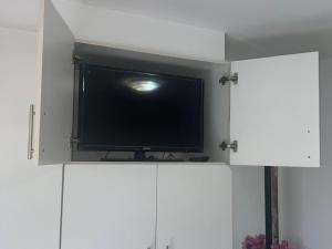 a flat screen tv sitting on top of white cabinets at Danlavie in Tyger Valley