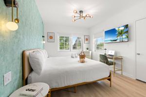 Un dormitorio con una cama blanca y un escritorio. en Bianco Hotel, en Miami