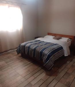 El NihuilにあるCasa de Montañaの窓付きのベッドルームのベッド1台