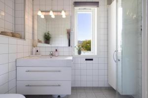 a white bathroom with a sink and a mirror at Tveitopark Apartments NO 2 in Øverland +21 photos