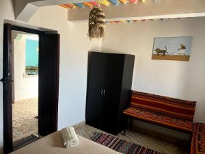 a room with a black cabinet and a bench at Superbe Stay in Taghazout