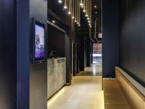 a hallway with a tv on the wall and a hallwayngthngthngthngthngth at Mercure Melbourne Therry Street in Melbourne