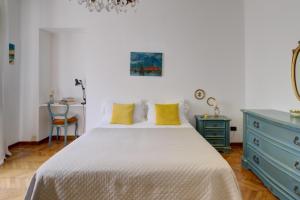 a bedroom with a white bed and a blue dresser at Coli's House in Turin