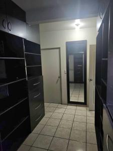 a bathroom with black cabinets and a mirror and a door at Private, centrally located, spacious and comfortable residence in Hermosillo
