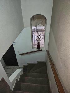 a staircase with a window and a vase on a shelf at Private, centrally located, spacious and comfortable residence in Hermosillo