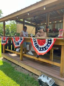 a group of people sitting at a picnic table with american flags at The Tiny tiki Hut in Springfield +2 photos