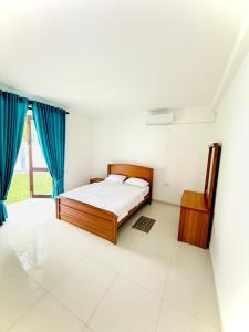 a bedroom with a bed and blue curtains at Alex's Place in Ja-Ela +18 photos