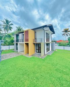 Una casa con un césped verde delante de ella. en Alex's Place, en Ja-Ela
