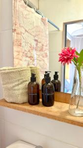 a bathroom shelf with three bottles of soap at Las Luciernagas Posada de Mar in La Pedrera