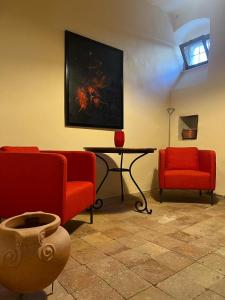 un salon avec deux chaises rouges et une table dans l'établissement Casa Beatrice, à Campochiaro