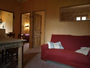 a living room with a red couch and a table at Ca la iaia Veva in Sant Joan les Fonts