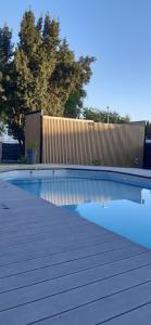 a swimming pool next to a wooden fence at La suite de cœurs avec jacuzzi in Gradignan