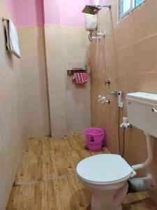 une salle de bain avec des toilettes blanches et une rose dans l'établissement Hotel ruposhi bangla, à Purbbadulki