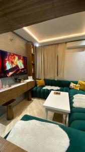 a living room with a green couch and a table at Luxury capital apartment in Rabat
